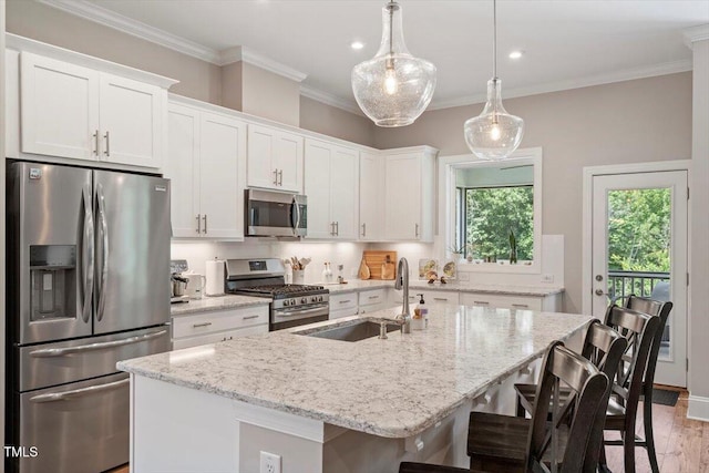223 Chauncey Cir, Chapel Hill, NC 27516 - kitchen with appliances with stainless steel finishes, white cabinetry, an island with sink, a breakfast bar, and crown molding