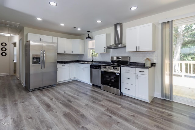 400 Minchew St SE, Wilson, NC 27893 - kitchen with stainless steel appliances, wall chimney exhaust hood, dark countertops, white cabinetry, and backsplash