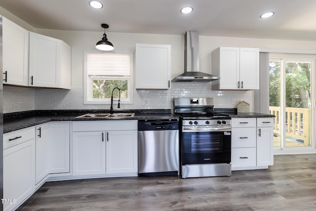 400 Minchew St SE, Wilson, NC 27893 - kitchen with appliances with stainless steel finishes, wall chimney exhaust hood, white cabinets, plenty of natural light, and recessed lighting