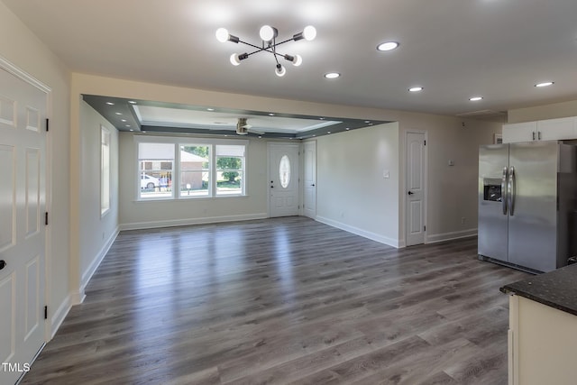 400 Minchew St SE, Wilson, NC 27893 - unfurnished living room featuring a ceiling fan, recessed lighting, a chandelier, a tray ceiling, and dark wood-style flooring