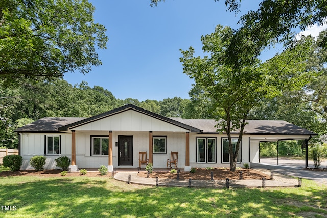 6005 Lake Wheeler Rd, Raleigh, NC 27603 - view of front of house with an attached carport, brick siding, a front lawn, roof with shingles, and board and batten siding