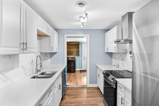 6005 Lake Wheeler Rd, Raleigh, NC 27603 - kitchen with appliances with stainless steel finishes, wall chimney exhaust hood, light countertops, washer / clothes dryer, and white cabinets