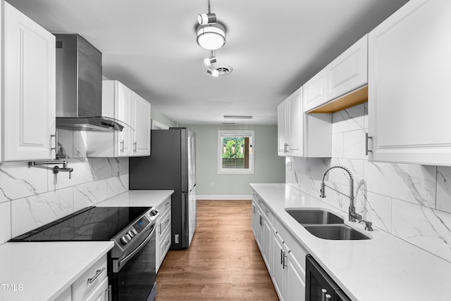 6005 Lake Wheeler Rd, Raleigh, NC 27603 - kitchen with electric range, wall chimney exhaust hood, white cabinetry, wood finished floors, and backsplash