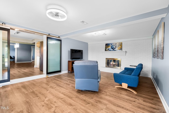 6005 Lake Wheeler Rd, Raleigh, NC 27603 - living area with wood finished floors, a fireplace, and brick wall