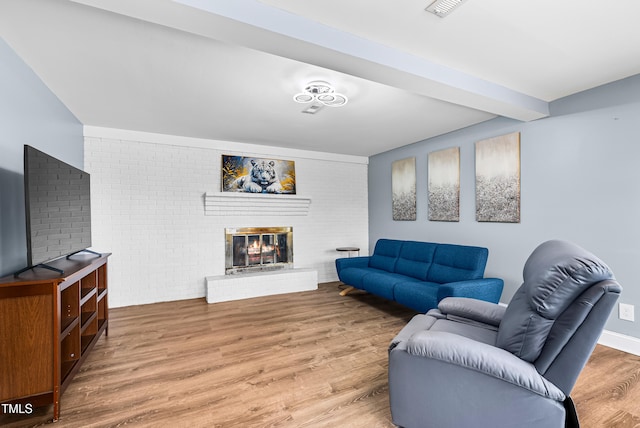 6005 Lake Wheeler Rd, Raleigh, NC 27603 - living room with light wood finished floors, brick wall, and a brick fireplace