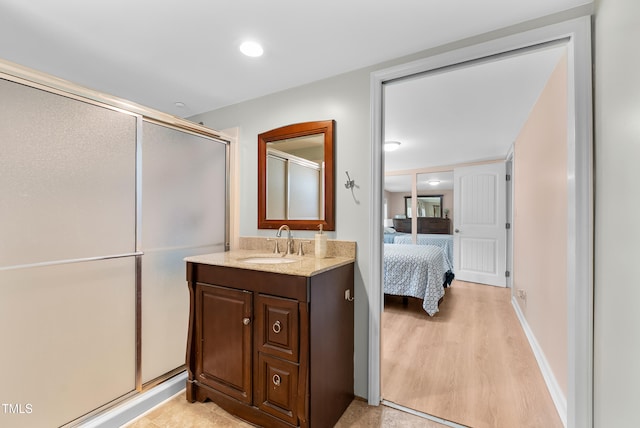6005 Lake Wheeler Rd, Raleigh, NC 27603 - ensuite bathroom with a stall shower, vanity, and wood finished floors