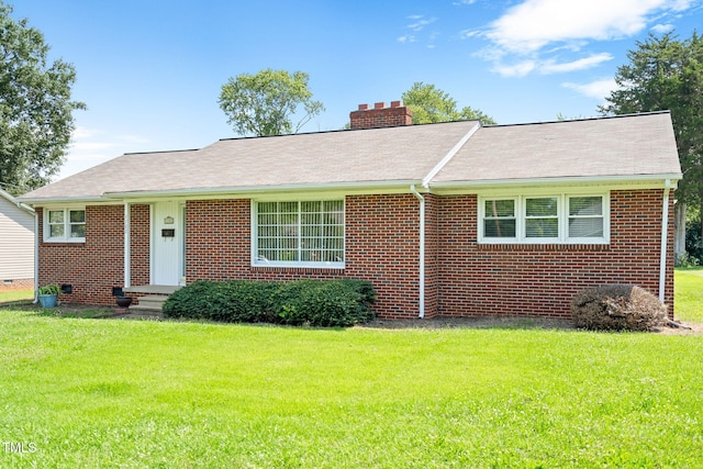 1702 Pinecrest St, Burlington, NC 27215 - view of front of home with a chimney, a front yard, and brick siding