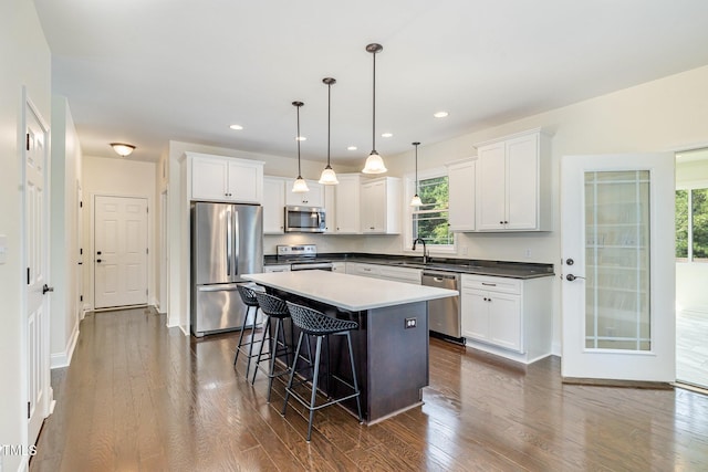 407 Kadir Womble Dr, New Hill, NC 27562 - kitchen featuring stainless steel appliances, a breakfast bar, dark wood-type flooring, white cabinetry, and recessed lighting