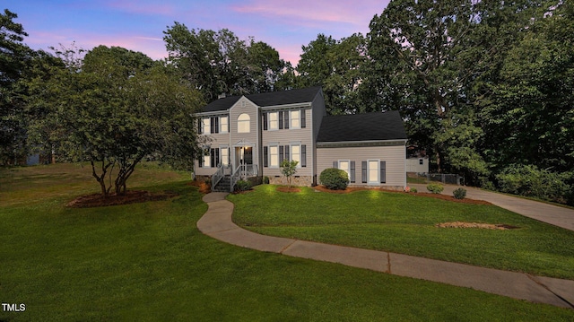 1524 Wedgewood Dr, Graham, NC 27253 - colonial-style house featuring a lawn, driveway, and view of scattered trees