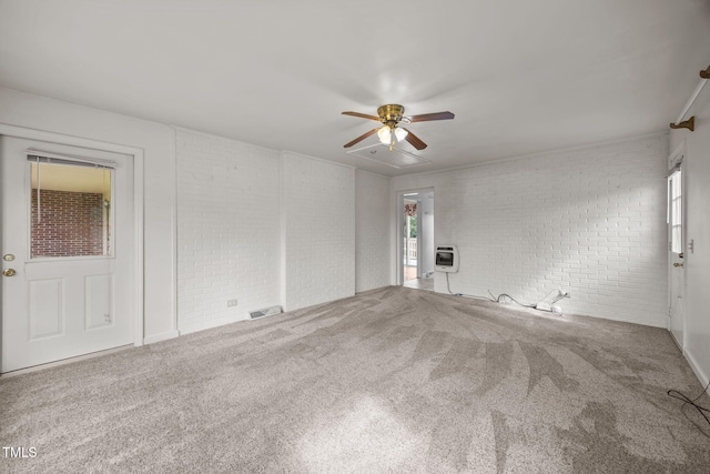 1105 Fontaine Rd, Roxboro, NC 27574 - spare room featuring brick wall, carpet, and a ceiling fan