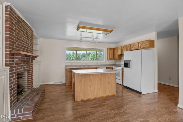 1105 Fontaine Rd, Roxboro, NC 27574 - kitchen featuring white appliances, light countertops, a center island, dark wood finished floors, and a brick fireplace