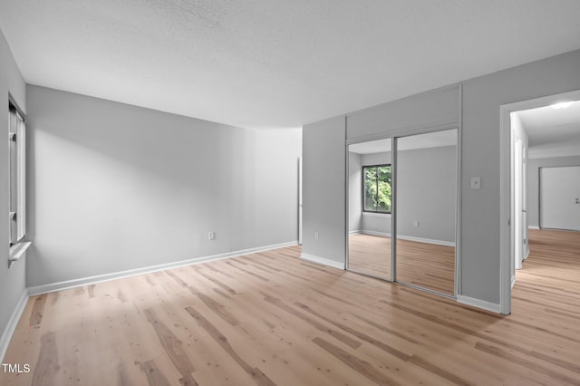 500 Umstead Dr Unit 103E, Chapel Hill, NC 27516 - unfurnished bedroom featuring light wood-type flooring, a closet, and a textured ceiling