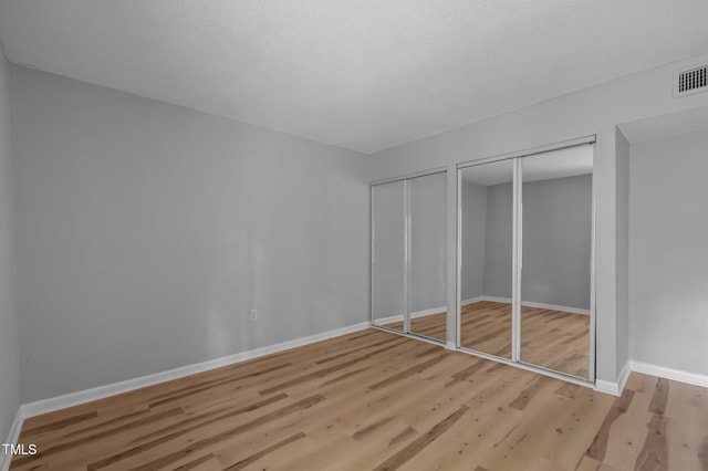 500 Umstead Dr Unit 103E, Chapel Hill, NC 27516 - unfurnished bedroom featuring two closets and light wood finished floors