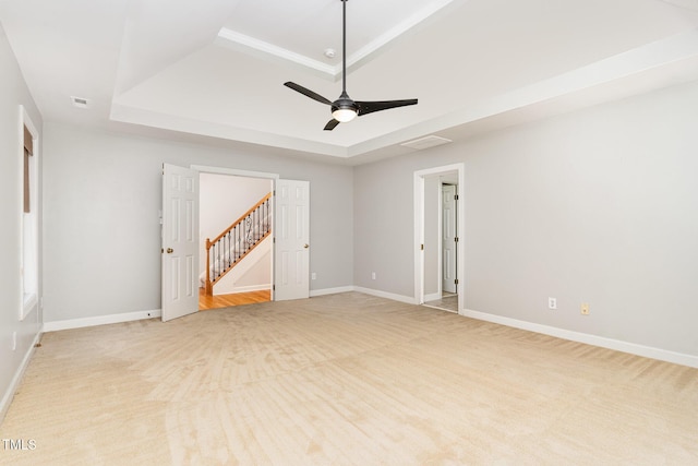 4060 Barton Park Pl, Raleigh, NC 27613 - spare room featuring a raised ceiling, light carpet, a ceiling fan, and stairway