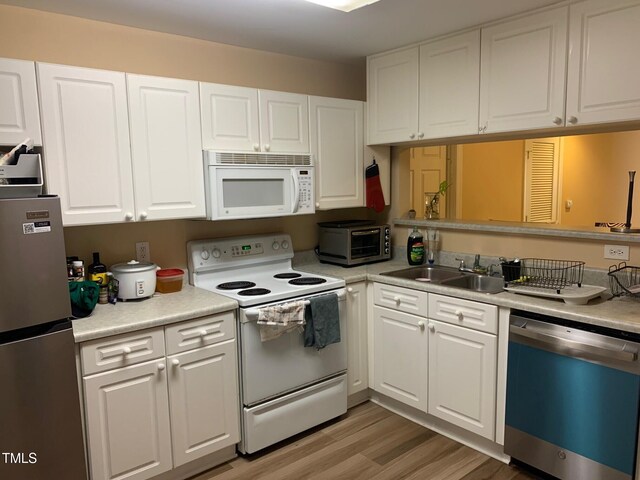 929 Morreene Rd Unit C-14, Durham, NC 27705 - kitchen featuring white appliances, white cabinetry, light countertops, and light wood-style floors