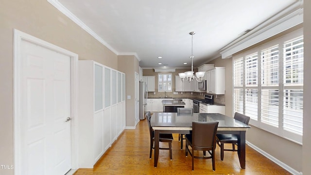 112 Salmon River Dr, Durham, NC 27705 - dining room featuring a chandelier, ornamental molding, and light wood-style flooring