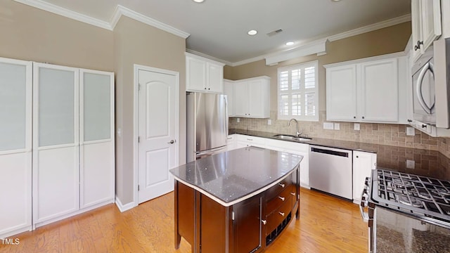 112 Salmon River Dr, Durham, NC 27705 - kitchen with stainless steel appliances, crown molding, light wood finished floors, dark stone countertops, and white cabinets