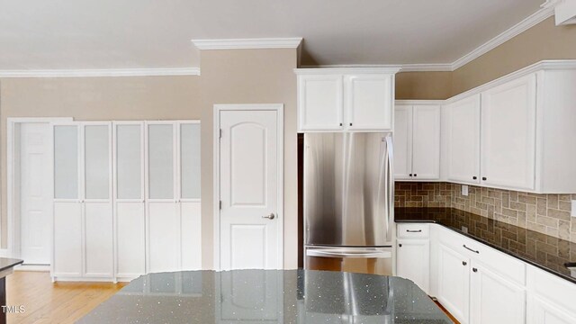 112 Salmon River Dr, Durham, NC 27705 - kitchen featuring freestanding refrigerator, white cabinets, backsplash, dark stone countertops, and crown molding