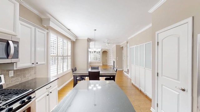 112 Salmon River Dr, Durham, NC 27705 - kitchen featuring stainless steel appliances, decorative backsplash, ornamental molding, light wood-style flooring, and white cabinets