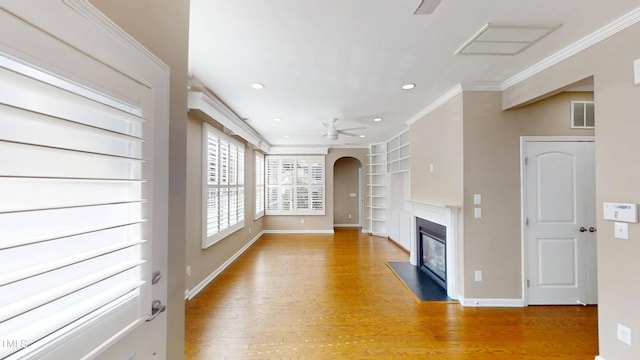 112 Salmon River Dr, Durham, NC 27705 - unfurnished living room featuring built in shelves, ceiling fan, light wood-style flooring, ornamental molding, and a fireplace with flush hearth