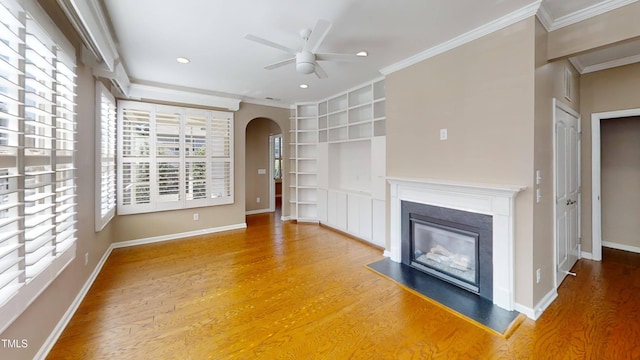 112 Salmon River Dr, Durham, NC 27705 - unfurnished living room with plenty of natural light, a ceiling fan, built in shelves, arched walkways, and crown molding