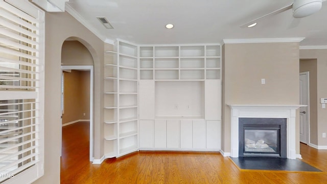 112 Salmon River Dr, Durham, NC 27705 - unfurnished living room with wood finished floors, arched walkways, built in shelves, ornamental molding, and a fireplace with flush hearth