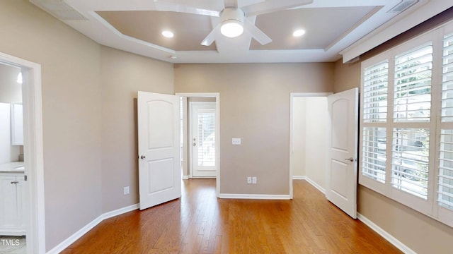 112 Salmon River Dr, Durham, NC 27705 - unfurnished bedroom with wood finished floors, multiple windows, a tray ceiling, and recessed lighting