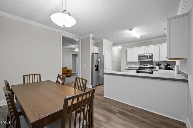 116 Justice St, Chapel Hill, NC 27516 - dining room with wood finished floors, a textured ceiling, and ornamental molding