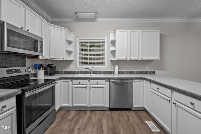 116 Justice St, Chapel Hill, NC 27516 - kitchen with appliances with stainless steel finishes, open shelves, white cabinets, a textured ceiling, and ornamental molding