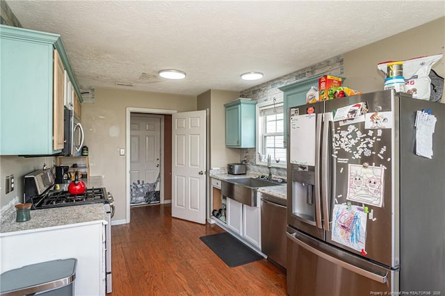 109 Hayes Ct, Raeford, NC 28376 - kitchen featuring appliances with stainless steel finishes, light countertops, dark wood-type flooring, and a textured ceiling