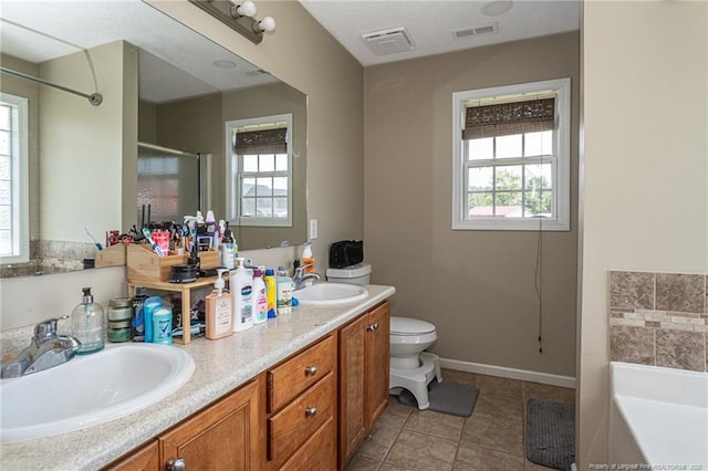 109 Hayes Ct, Raeford, NC 28376 - full bath with double vanity, a garden tub, plenty of natural light, and tile patterned floors