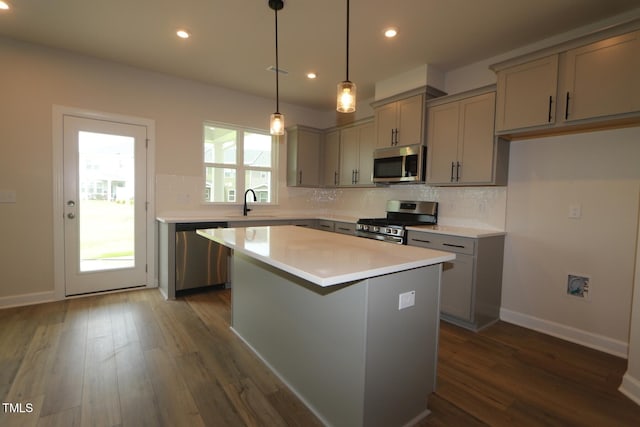 1218 Tredenham Way, Durham, NC 27703 - kitchen featuring stainless steel appliances, gray cabinets, tasteful backsplash, dark wood-type flooring, and a center island