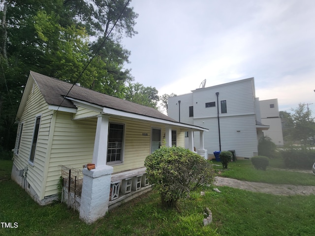 1106 Fargo St, Durham, NC 27707 - view of front of home with covered porch, a front yard, and a shingled roof