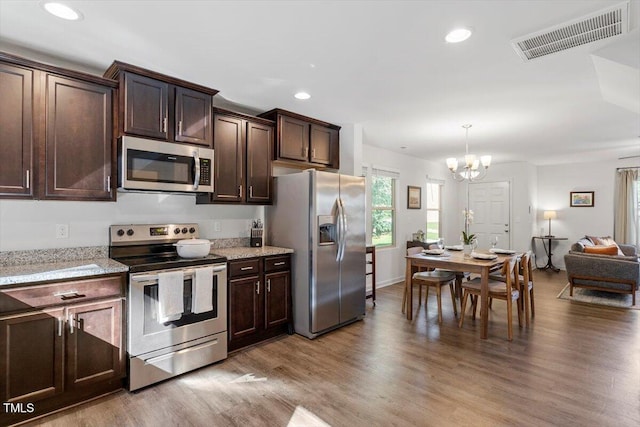 534 Hobkirks Pl, Durham, NC 27704 - kitchen featuring stainless steel appliances, a chandelier, dark brown cabinetry, light wood-type flooring, and recessed lighting