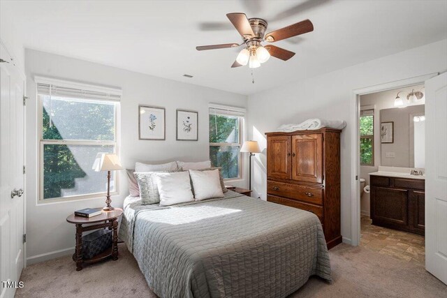534 Hobkirks Pl, Durham, NC 27704 - bedroom with light colored carpet, ensuite bathroom, and a ceiling fan