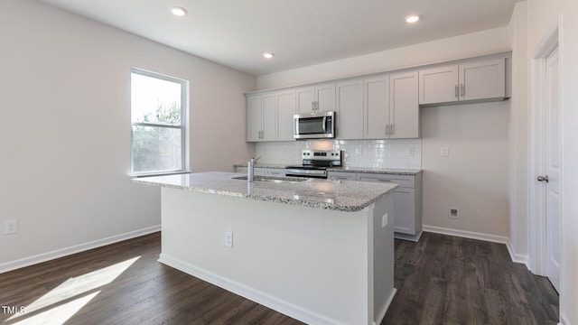 170 Babbling Creek Dr, Youngsville, NC 27596 - kitchen with stainless steel appliances, an island with sink, dark wood-style flooring, tasteful backsplash, and light stone counters