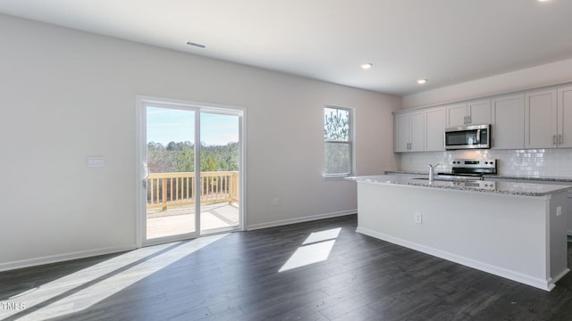 170 Babbling Creek Dr, Youngsville, NC 27596 - kitchen with stainless steel appliances, an island with sink, decorative backsplash, dark wood finished floors, and recessed lighting