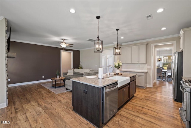 824 Stanly House St, Wake Forest, NC 27587 - kitchen with stainless steel appliances, ceiling fan, a kitchen island with sink, light wood-style floors, and crown molding