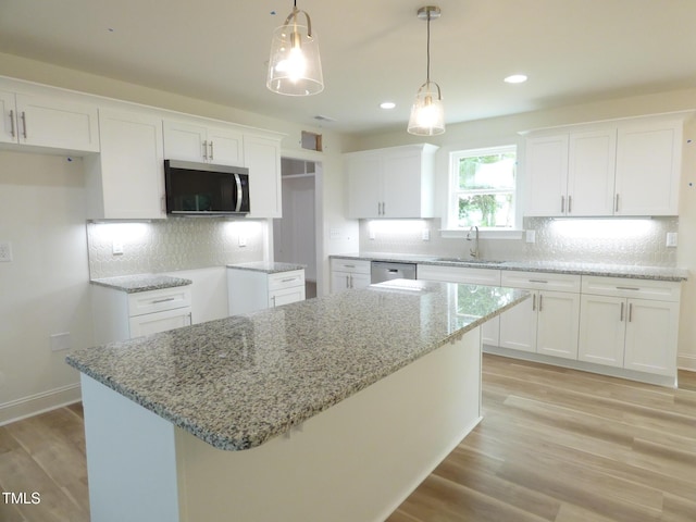 5610 Plain View Highway, Dunn, NC 28334 - kitchen with appliances with stainless steel finishes, light stone counters, white cabinetry, light wood-style flooring, and pendant lighting