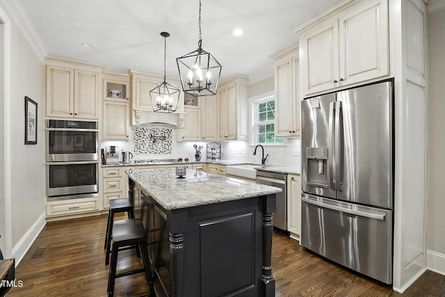 164 Avocet Ln, Clayton, NC 27520 - kitchen with appliances with stainless steel finishes, cream cabinetry, a chandelier, tasteful backsplash, and recessed lighting