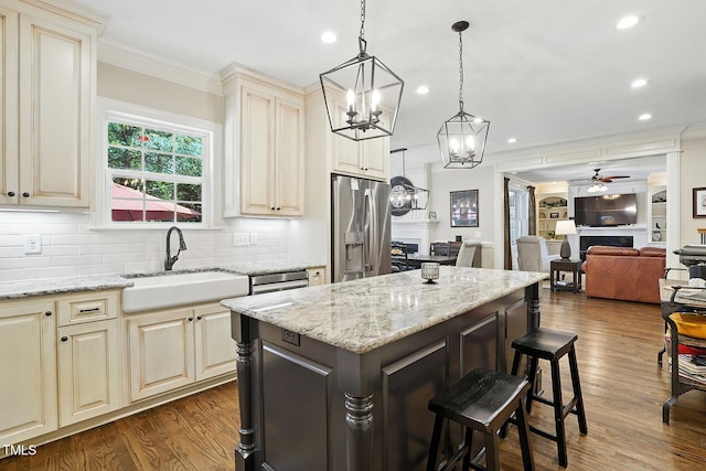 164 Avocet Ln, Clayton, NC 27520 - kitchen with stainless steel refrigerator with ice dispenser, cream cabinets, a ceiling fan, crown molding, and a breakfast bar