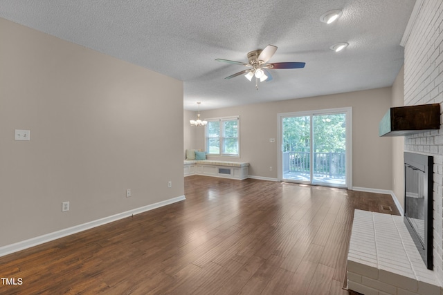 4140 Willow Haven Ct, Raleigh, NC 27616 - unfurnished living room featuring a fireplace, ceiling fan, a chandelier, dark wood-style floors, and a textured ceiling