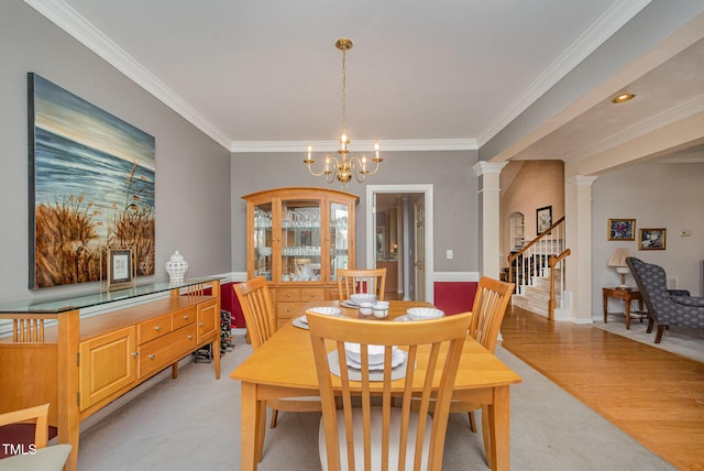 302 Caraway Ln, Cary, NC 27519 - dining room featuring crown molding, decorative columns, a chandelier, stairway, and light carpet