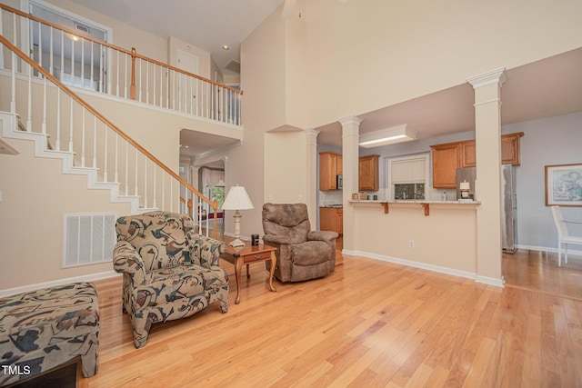 302 Caraway Ln, Cary, NC 27519 - living area featuring light wood-style floors, decorative columns, a high ceiling, and stairway