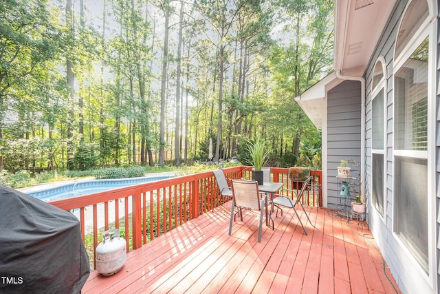 302 Caraway Ln, Cary, NC 27519 - wooden terrace featuring an outdoor pool, outdoor dining area, view of scattered trees, and a grill
