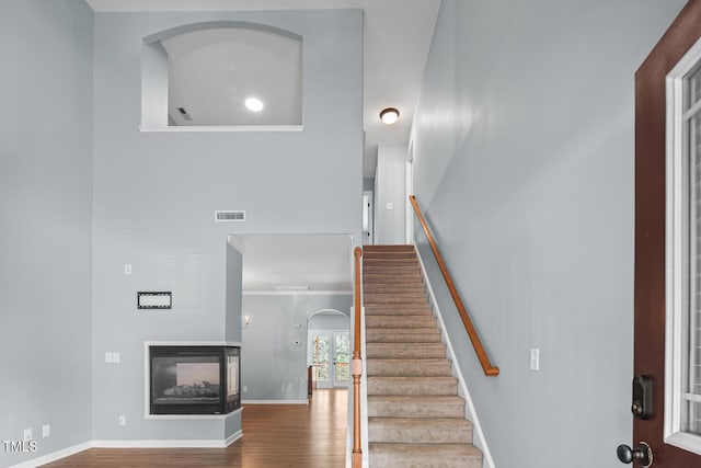 145 Mariah Towns Way, Garner, NC 27529 - stairs with wood finished floors, arched walkways, and a multi sided fireplace