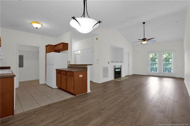 612 Marshtree Ln Unit 304, Fayetteville, NC 28314 - kitchen with freestanding refrigerator, ceiling fan, dark countertops, brown cabinetry, and lofted ceiling