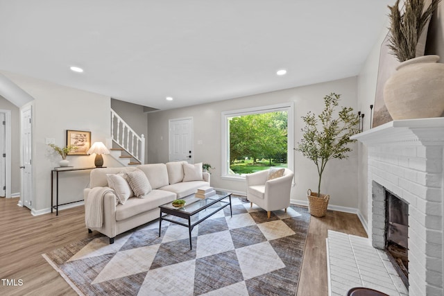 5721 Meadow Run, Knightdale, NC 27545 - living room with a brick fireplace, stairs, wood finished floors, and recessed lighting