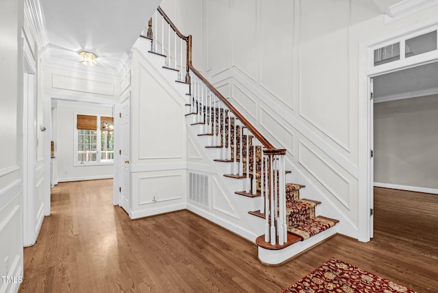 105 Bathgate Ln, Cary, NC 27513 - stairway featuring a decorative wall, wood finished floors, and crown molding