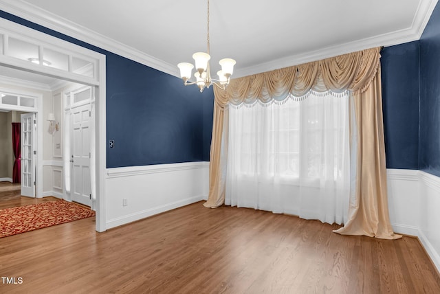 105 Bathgate Ln, Cary, NC 27513 - unfurnished dining area featuring a chandelier, a wainscoted wall, crown molding, and wood finished floors